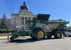 A John Deere X9 combine is parked in front of the Saskatchewan Legislature in Regina.