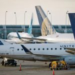 Passenger planes parked at the gates of a major airport.