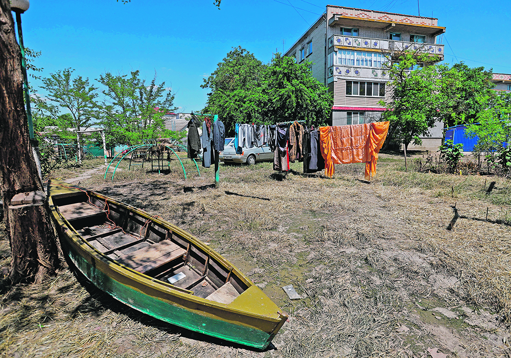 A boat sits in the yard of an apartment building after floodwaters receded following the collapse of the Nova Kakhovka dam in Ukraine.