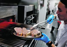 A chef cooks beef steaks at the kitchen of Wolfgang's Steakhouse restaurant, in Beijing.