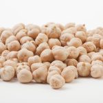 A pile of kabuli chickpeas on a white table.
