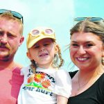 A blond couple with a small girl portrait on a sunny day