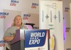Blond woman at a podium with the words "World Pork Expo" displayed upon it.