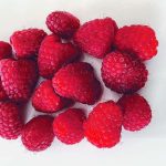 a bunch of fresh raspberries on a white background