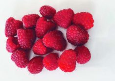 a bunch of fresh raspberries on a white background
