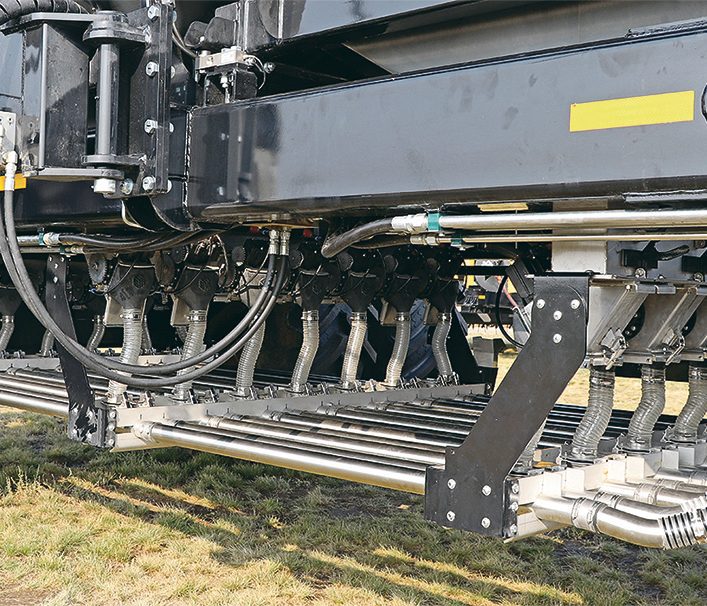 A close up of numerous stainless steel pipes on an air seeder.