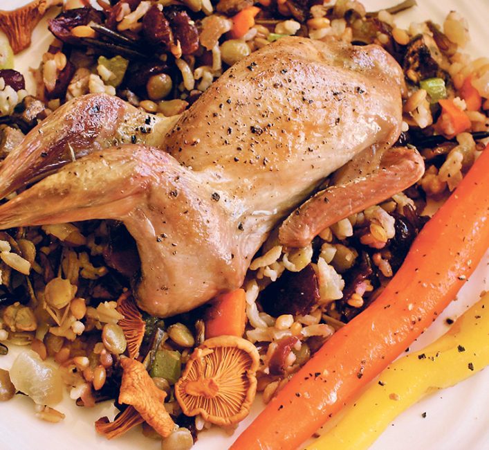 A small roasted chicken on a bed of rice pilau
