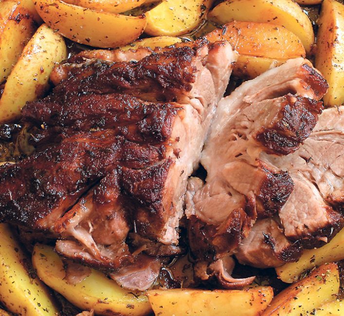 Thickly sliced roast meat on a bed of potato wedges