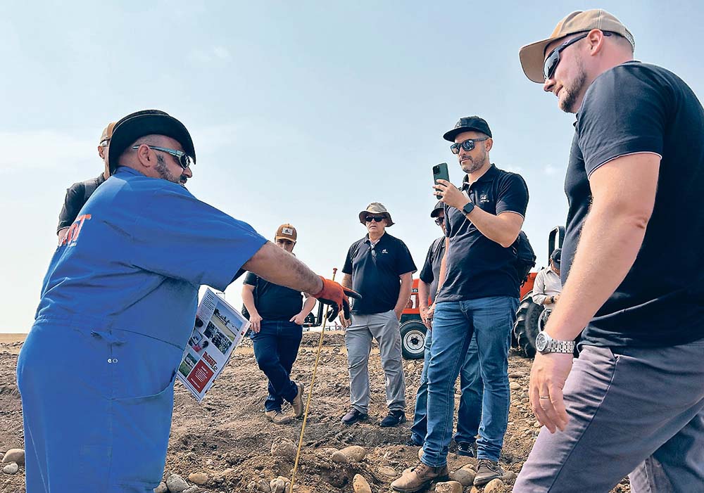 Farmers from Brazil’s Agraria co-operative listen to Sam Abourjelly explain his company’s rock crusher while they attended the Ag in Motion farm show held in July near Langham, Sask.  |  Ed White photo