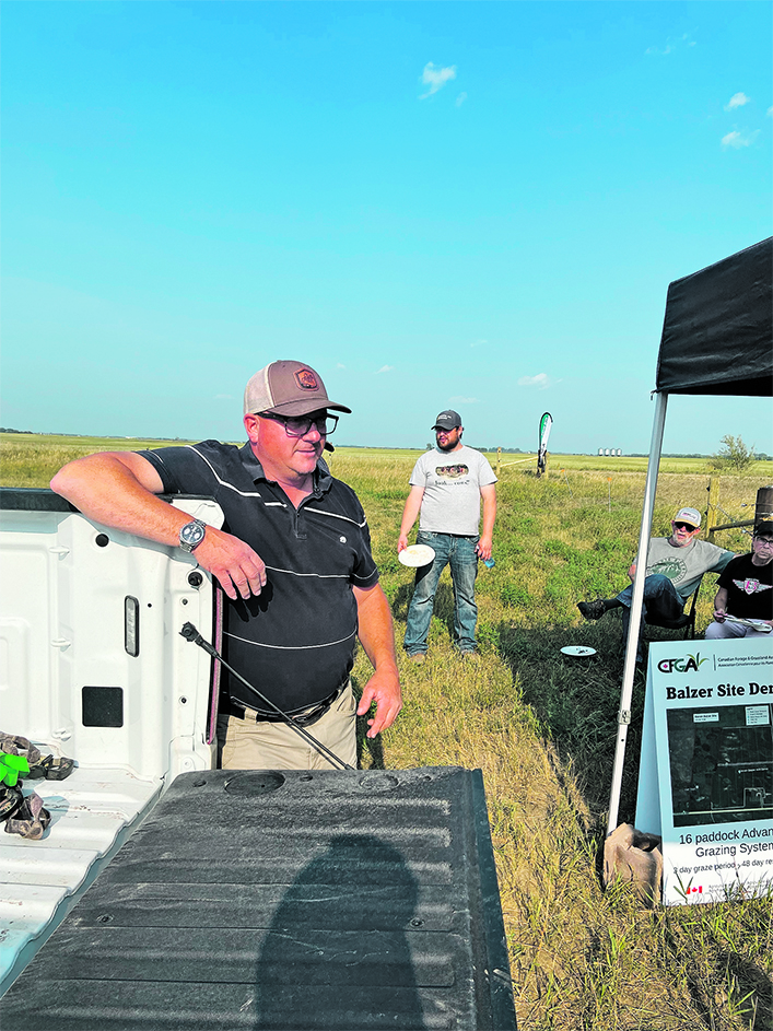 Steven Balzer leans on a pickup as he talks about a hay field near Langham, Sask., he is transitioning to a pasture.