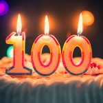 A birthday cake with three candles in the shape of numbers - 100 - on it.