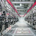 Engines hang from a ceiling-mounted conveyor in an AGCO assembly plant.