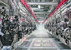 Engines hang from a ceiling-mounted conveyor in an AGCO assembly plant.
