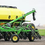 A John Deere air seeder sits idle.