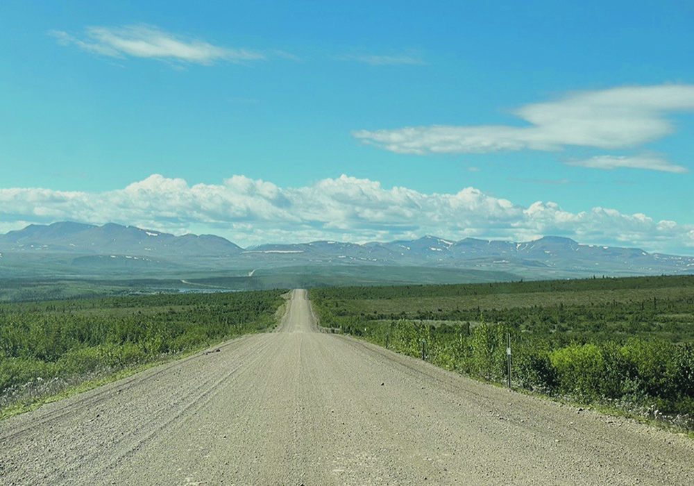 The isolated Dempster Highway winds over the tundra and through round-topped mountains under a beautiful blue sky.  |  Betty Ann Deobald photo