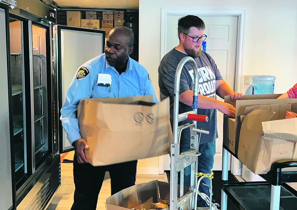 Winnipeg House of Bread co-ordinator Winston Robb, left, and Joey Dearborn of Manitoba Pork load the food bank program’s new freezer with donated ground pork.  |  Ed White photo