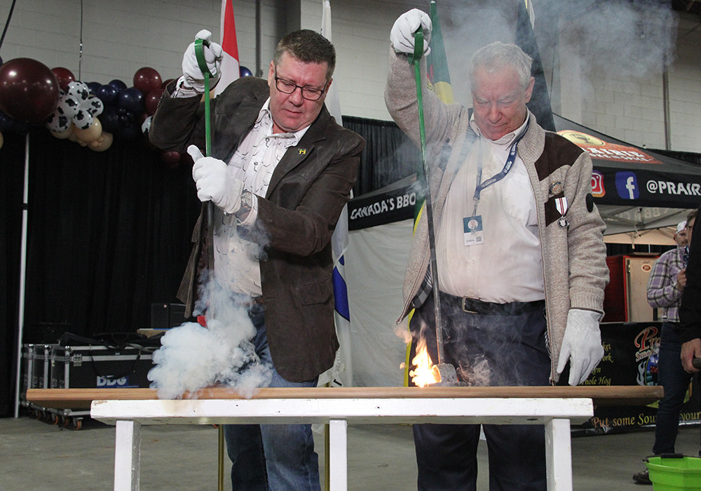 Saskatchewan premier Scott Moe and retired agricultural broadcaster Jim Smalley burned the brand to officially open Canadian Western Agribition Nov. 20. | Becky Zimmer photo