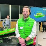 John Deere’s Jonathan Edwards stands in front of the company’s new Active Slope Adjustment for combine cleaning shoes at Agritechnica. | John Greig photo