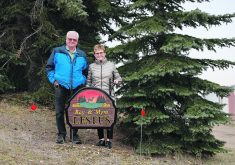 Ray and Myra Lestus, of Strome, Alta., stand in front of their farm sign. The couple retired from farming early with no regrets.  |  Mary MacArthur photo
