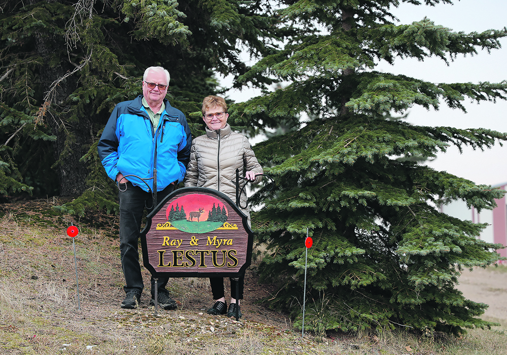 Ray and Myra Lestus, of Strome, Alta., stand in front of their farm sign. The couple retired from farming early with no regrets.  |  Mary MacArthur photo