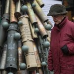 A woman passes by a symbolic Christmas tree made from used artillery shells and parts of rockets that have been brought to the Ukrainian capital from the front line. | Reuters/ Gleb Garanich photo
