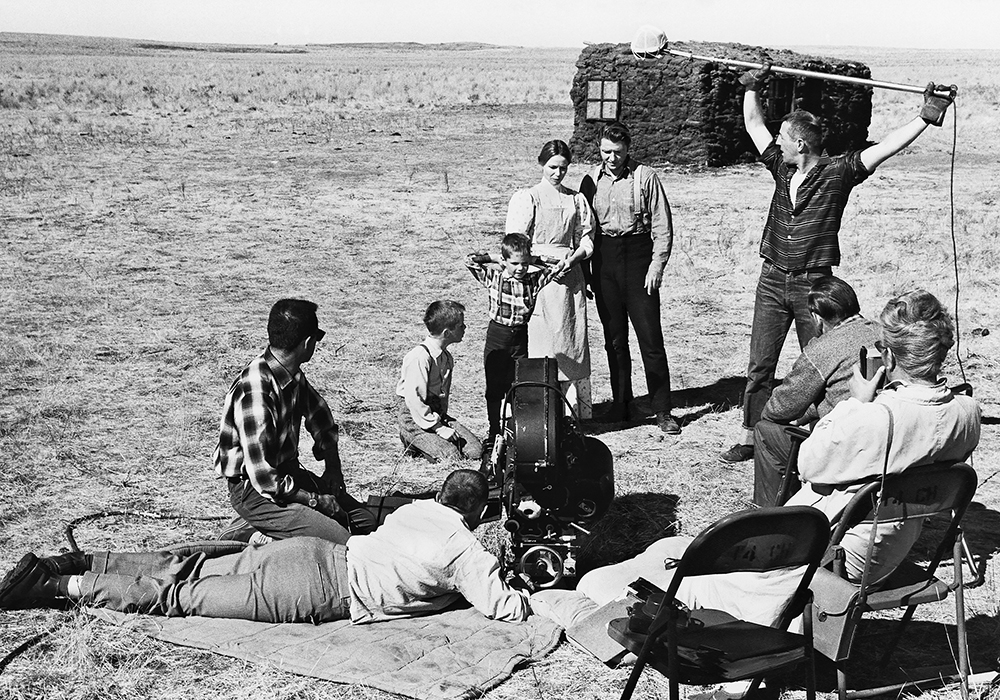 A film crew shoots a scene with the actors playing the pioneer Greer family in Drylanders. The sod house in the background was built for the film on the Thierman farm near Webb, Sask.  |  Photo courtesy of the National Film Board of Canada