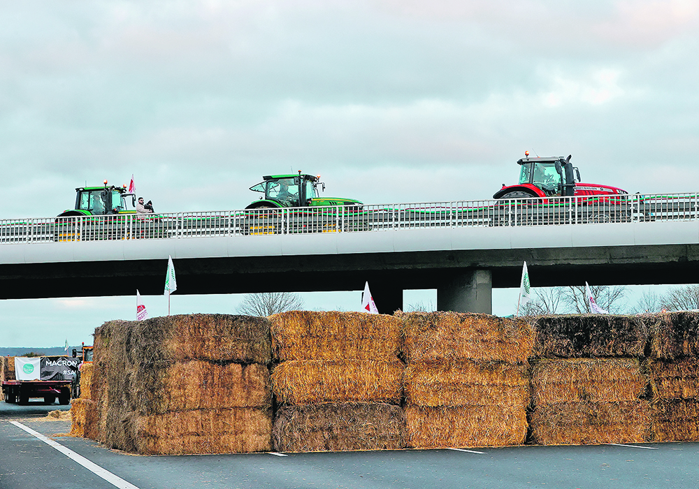 French farmers block a highway near Paris Jan. 30 with their tractors, hay bales and tents during a protest over price pressures, taxes and environmental regulation, grievances shared by producers across Europe.  |  Reuters/Abdul Saboor photo