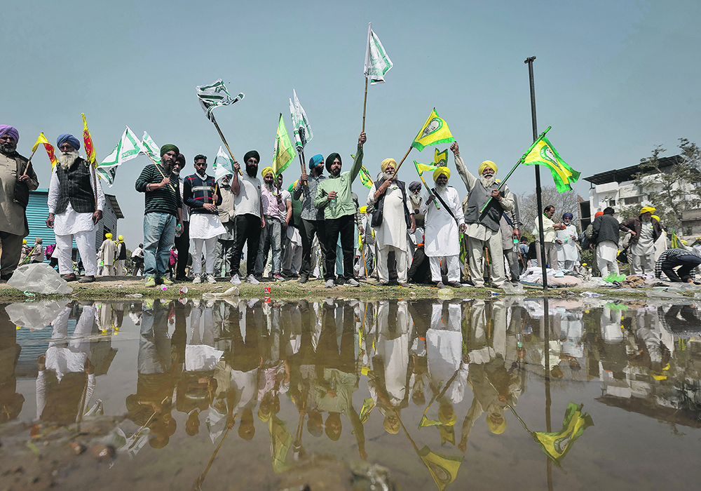 Farmers raise slogans during a grand village council meeting as part of a protest to press for the better crop prices promised to them in 2021.   |  Reuters/Adnan Abidi photo