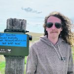 Tyler Eresman, a wildlife and outreach technician with the Milk River Watershed Council Canada, stands next to a bat monitor. | Photo supplied by Milk River Watershed Council Canada