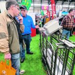 Bert Tichelaar, right, owner of Aryquip Ltd., talks to Peter Mettler about how his company’s pig sorter software could be mounted on an existing sorter. | Diana Martin photo