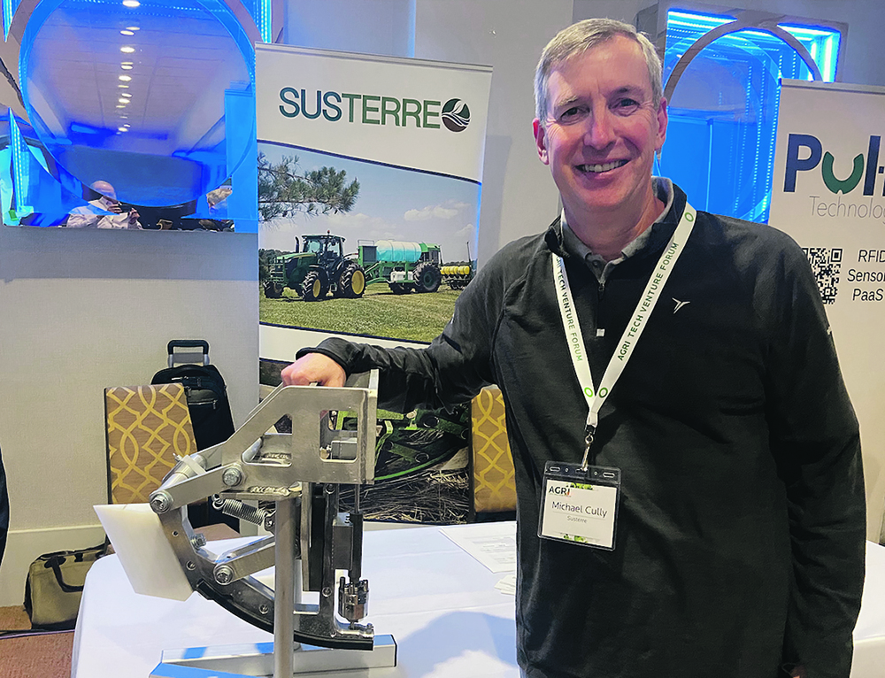 Susterre CEO Michael Cully is shown with the company’s high pressure water jet unit that fits onto planters and opens up residue and the soil for the rest of the seed placement system.  |  John Greig photo
