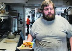 Brady Peterson, owner and chef of Pete’s, a barbecue restaurant, prepares a sandwich in Smith Center, Kansas. His business is one of many feeling the pinch as American farmers face falling incomes.  |  Reuters/Heather Schlitz photo