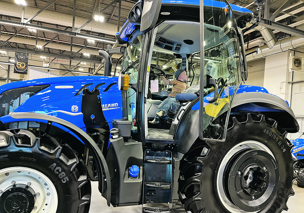 Two-year-old Peter Braun checks out a new tractor at Canada’s Farm Show in Regina last week. He was at the show with his father, James, twin brother Thomas and grandfather, Allan Braun. Starting next year, the show is moving to March. |  Karen Briere photo