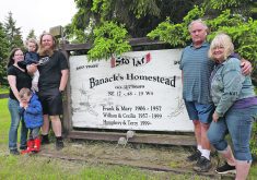 Amanda and Nick Banack with their children, Connor and Morgan, and Humphrey and Terry Banack stand beside the farm sign at the end of their driveway listing the previous Banack families to live on the farm.  |   Mary MacArthur photo