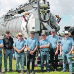 Staff members stand in front of Advance Tank Production’s new biogas slurry trailer at the recent Ag in Motion farm show. | John Greig photo