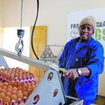 An employee at Project Canaan in Eswatini submerges eggs in an egg bath as part of efforts to increase their shelf life. | Heart for Africa photo