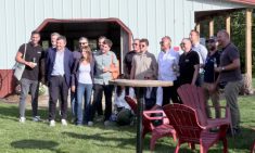 A group of attendees at the networking event pose for a 'family photo' outside the Business Lounge at Canada's Outdoor Farm Show. | Greg Berg photo