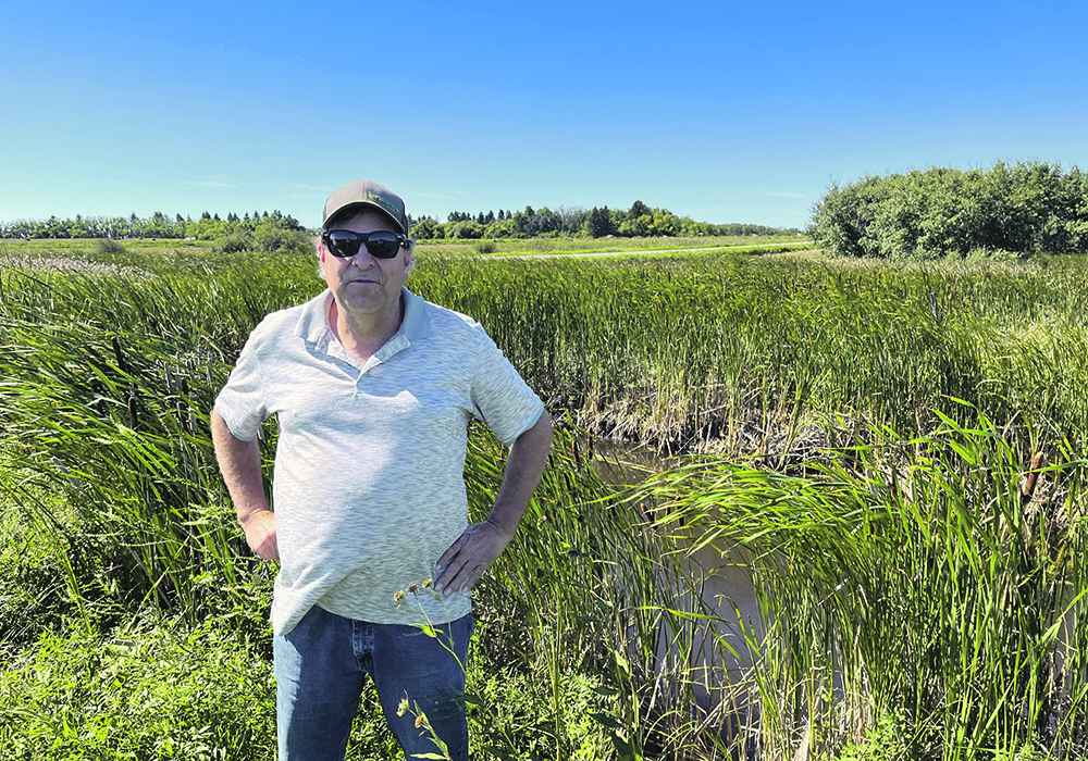 Lane Mountney stands near the adequate outlet of a planned 28-quarter drainage project in the Rural Municipality of Wawken in southeastern Saskatchewan. He opposes the project, but his land has been designated as the adequate outlet. |  Karen Briere photo