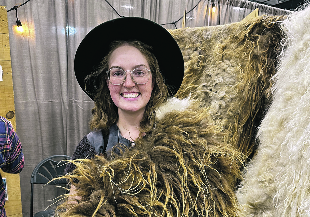 Victoria Radauskas from St. Genevieve, Man., holds an Icelandic sheepskin at the Between Two Farms booth during last month’s Manitoba Fibre Festival in Winnipeg. | Don Norman photo