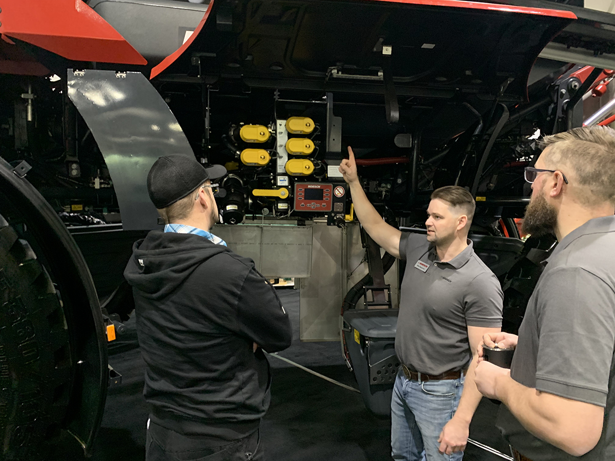 A representative from Horsch talks about a new Leeb 8.460 VL sprayer with a farmer at the 2025 Crop Production Show in Saskatoon.
