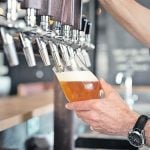 Beer being poured from a tap into a glass in a bar