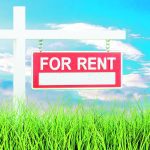 Stock graphic image of a "For Rent" sign in a grass field with a few puffy clouds in the blue sky background.