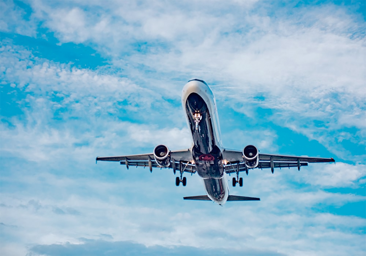 A stock photo of a large passenger jet taking off, about to fly directly overhead.
