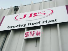 Looking up at the JBS sign on the side of their Greely, CO, beef plant.
