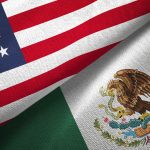 A U.S. flag on top of a Mexican flag.