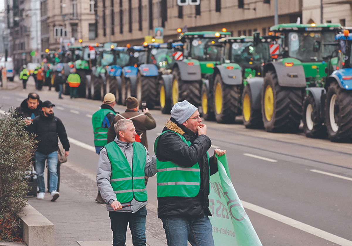 A long line of tractors is parked end-to-end on a city street as German farmers protest against plans to end subsidies or tax breaks on agricultural diesel, among other things, in 2024.