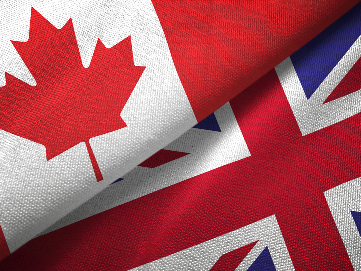 A Canadian flag and a U.K. flag beside each other on a table.