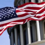 The American flag flies in front of the Capitol Building in Washington.