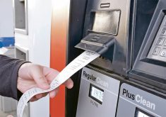 A customer gets a receipt directly from the gas pump after filling up with fuel.