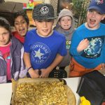 Five students from the Spuds in Tubs program stand in front of a tray with fresh-baked french fries on it.
